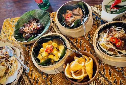 Spread of Indonesian dishes on a batik table runner.