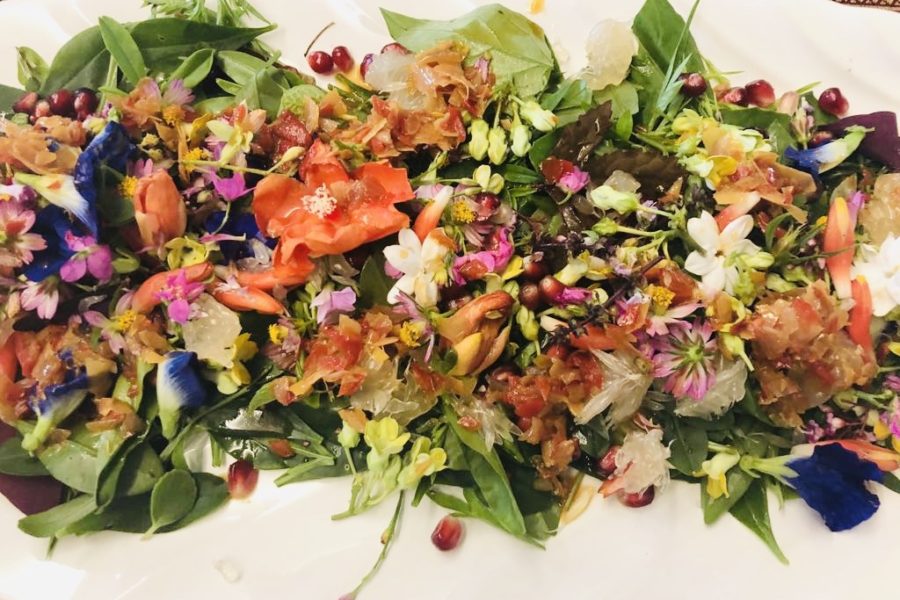 Plate of salad with colourful flowers.