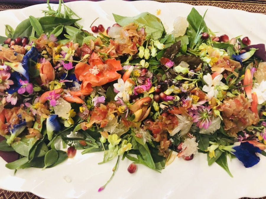 Plate of salad with colourful flowers.