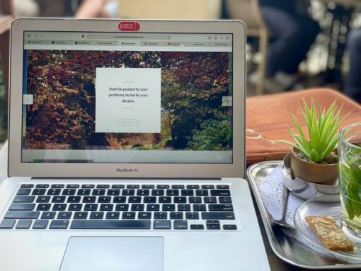 Open laptop next to a cup of coffee.