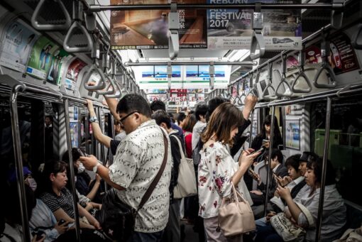 Commuters in a crowded subway busy with their mobile phones and tablets. 