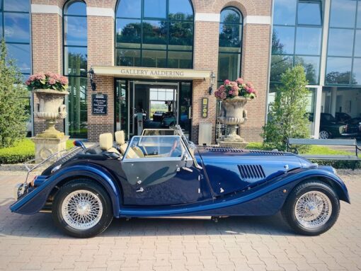 Special edition convertible Morgan classic car in blue photographed in front of a gallery.