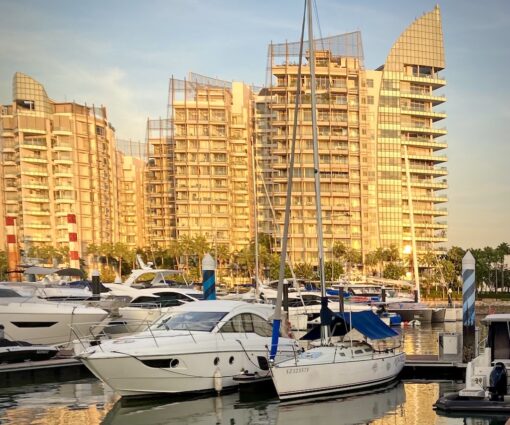 Seafront luxury apartments with marina in front, with docked yachts.