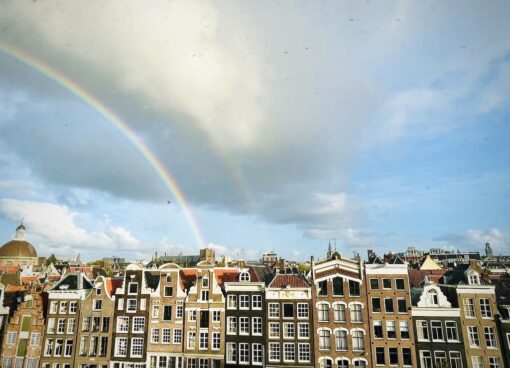 Rainbow over historical houses in Amsterdam.