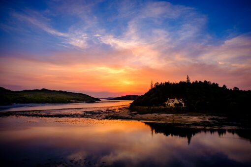 Beautiful sunset shot of area near Fort Williams with sun setting behind a hill in water.