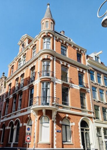 Majestic corner apartment block in Amsterdam, dating back to 1890s, with impressive facade with turn-of-the-century details.