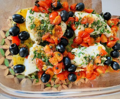 Grilled cod in olive oil with lots of black olives, cherry tomatoes and parsley.