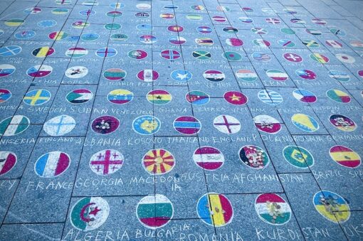 Country flags painted on sidewalk. 