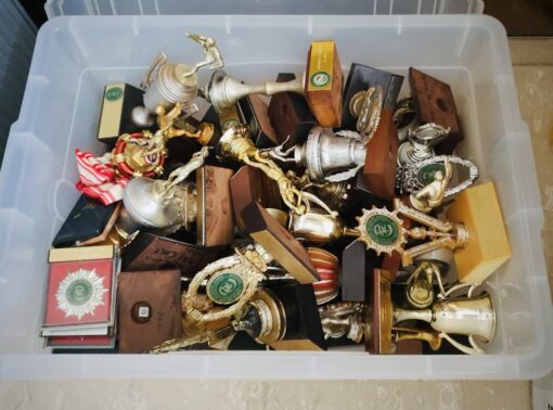 Container filled with sports trophies and medals.