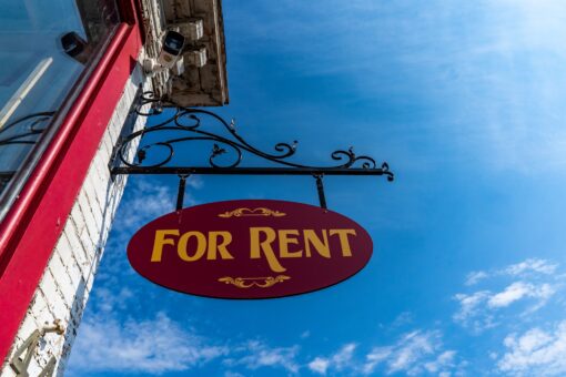 'For rent' sign hanging outside a house.