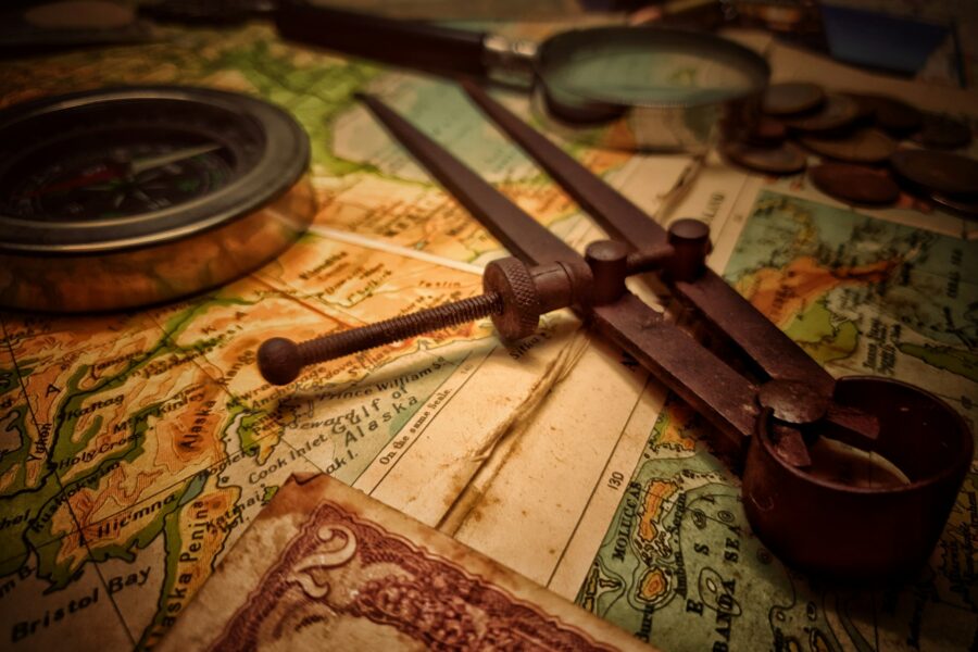Navigation tool, compass and magnifying glass on an old map.