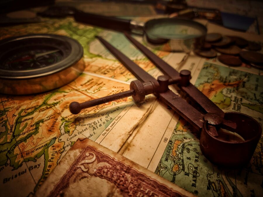 Navigation tool, compass and magnifying glass on an old map.