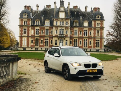 Shot of a BMW SUV parked in front of a Grand Maison.
