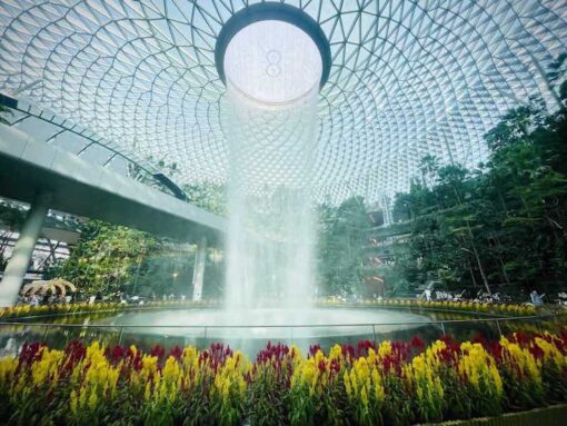 Huge dome fountain flowing into flower pond.