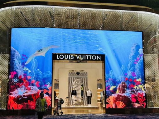 Louis Vuitton storefront with gigantic TV showing marine life as entrance. 
