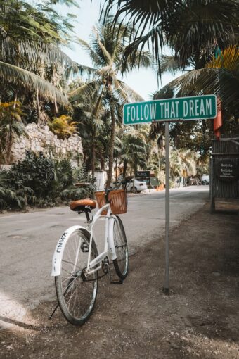 Bicycle in front of a signpost "Follow That Dream".