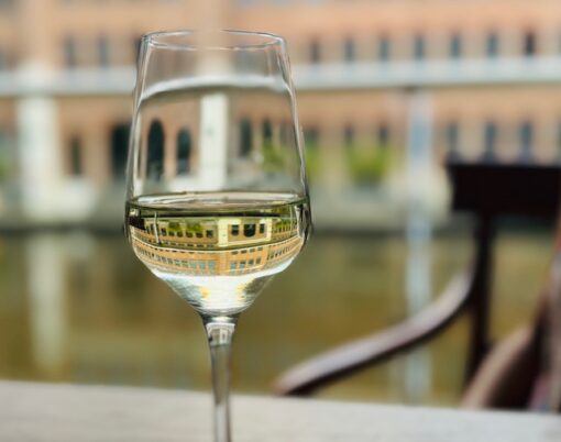 Image of building captured in a glass of wine. 