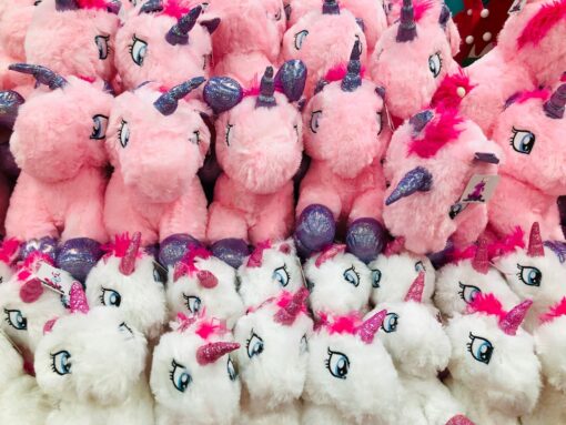 Rows of pink and white unicorns soft toys.