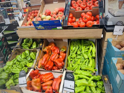 Boxes of red and green tomatoes and peppers.