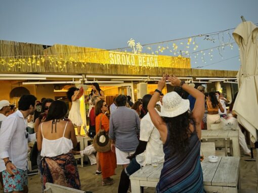 Dancing crowd at a beach club at sunset.