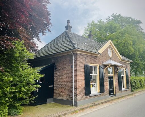 Picture of a charming cottage surrounded by mature trees.