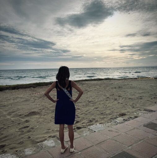 Woman looking at an empty plot of land right on the beach at sunset.