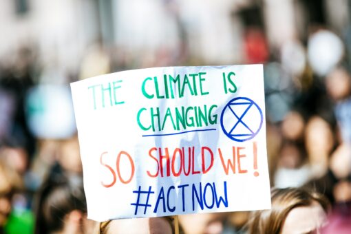 Climate change protest sign "Climate is changing, so should we. Act now!"