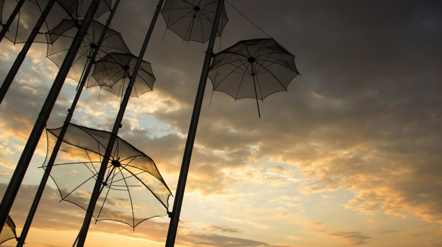 Several open umbrellas hanging at dusk.