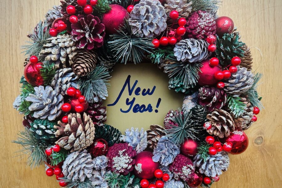 Wreath with New Year written in the hollow middle in vivid green red and snowy white.