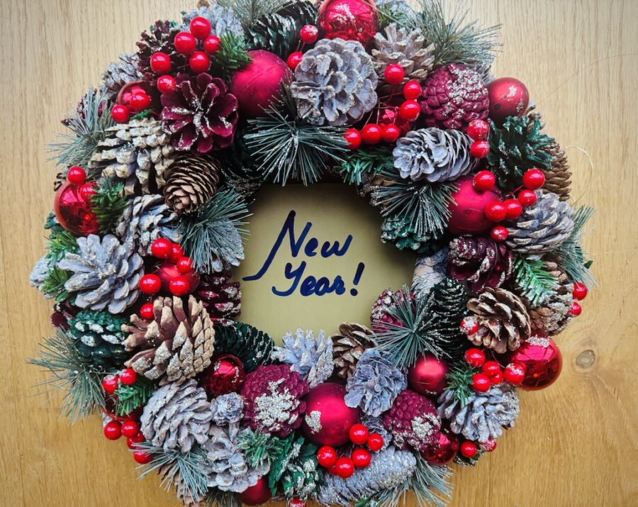 Wreath with New Year written in the hollow middle in vivid green red and snowy white.